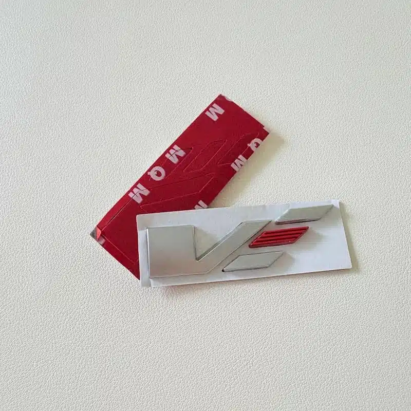 Cadillac V Badge 2Pcs Set 2 Rear of the Cadillac V badge showing the 3M adhesive backing